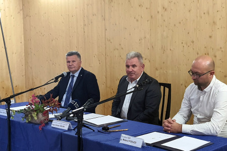 Župan, minister in direktor na novinarski konferenci sedijo za mizo