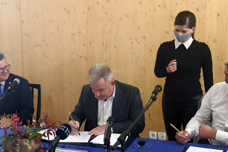 Župan, minister in direktor podpisujejo akt o zavarovanju