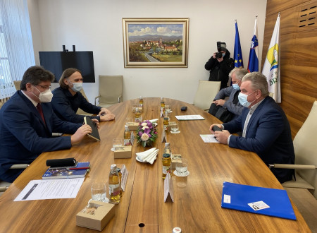 Minister in župan s sodelavcema v sejni sobi za mizo pri razgovoru