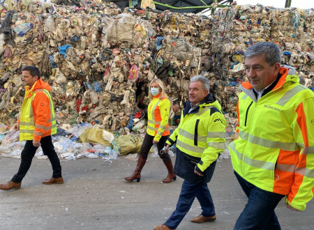 Minister in drugi udeleženci stojijo na dvorišču podjetja Kostak