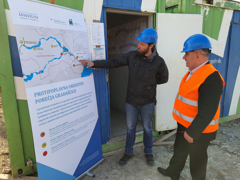 Minister Vizjak (desno) si ogleduje projekt protipoplavne ureditve Gradaščice