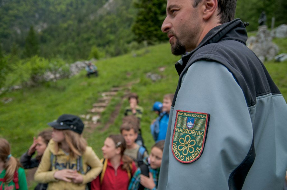 Fotografija naravovarstvenega nadzornika znakom na uniformi