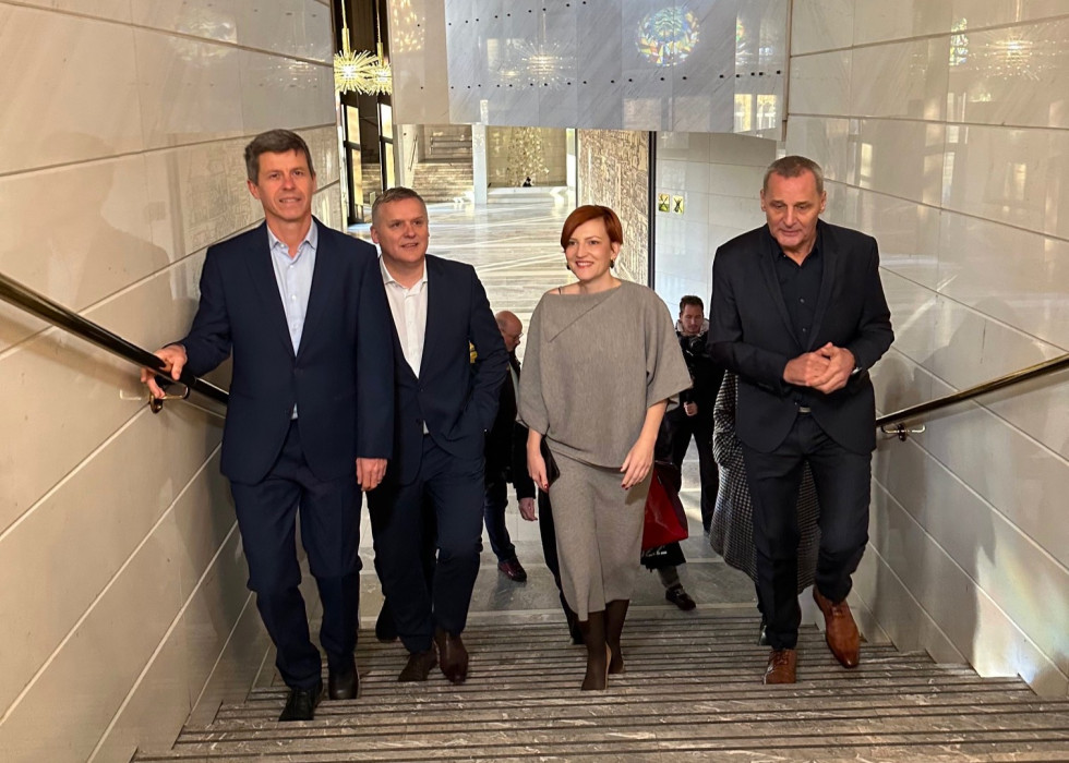 4 osebe se vzpenjajo po stopnicah.