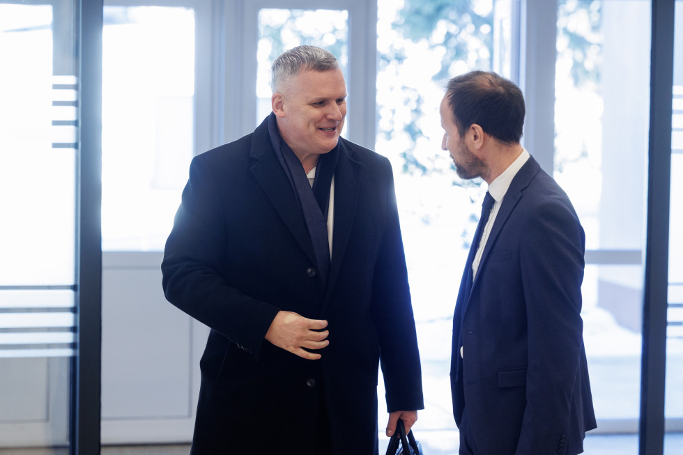 Dva moška pred vhodom v stavbo