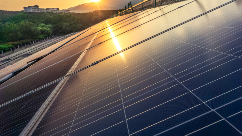 Solarni paneli na strehi. V njih odsev zahajajočega sonca. 