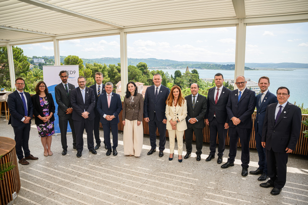 Udeleženci konference stojijo v vrsti