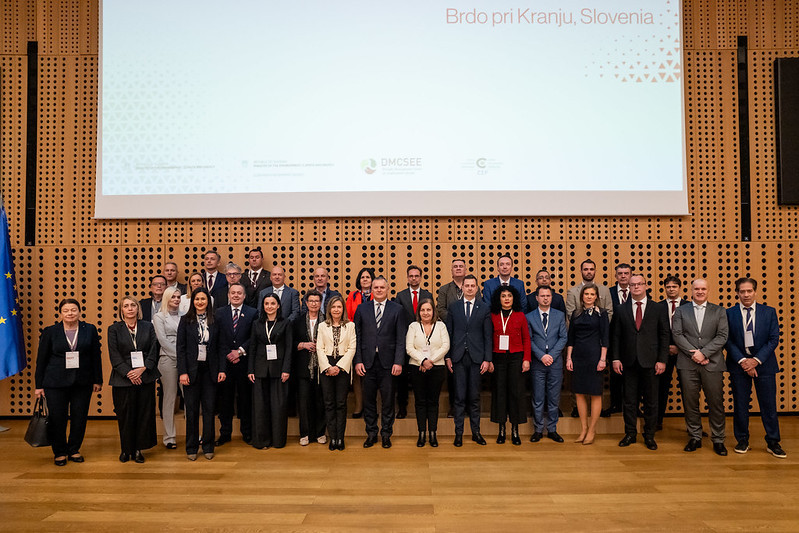 Skupina ljudi stoji, skupinska fotografija vseh udeležencev konference 