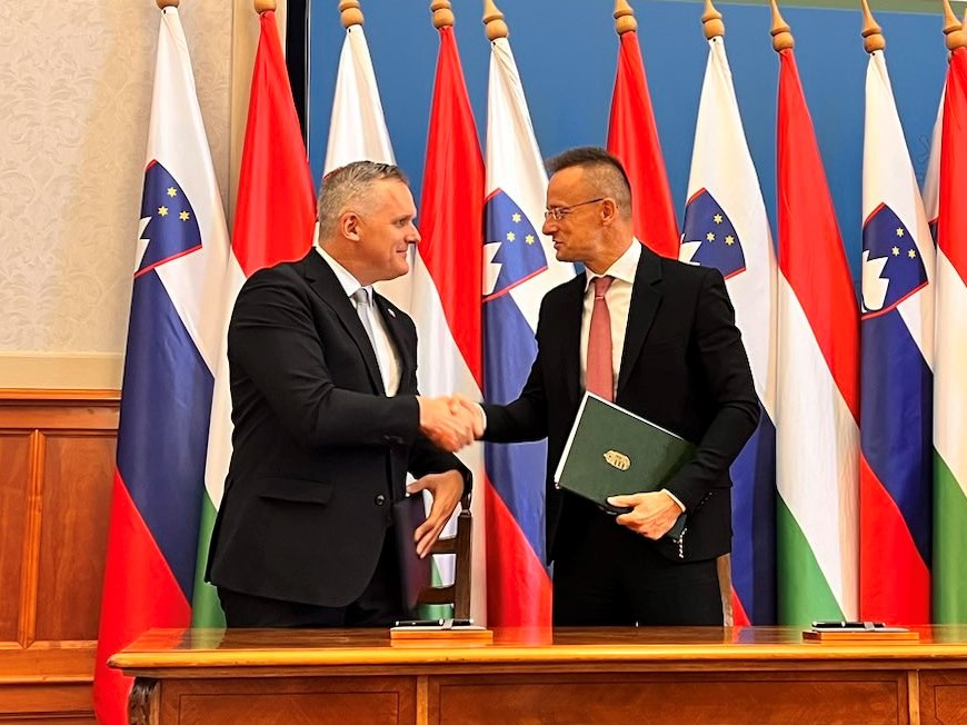 Ministers shaking hands, flags in background