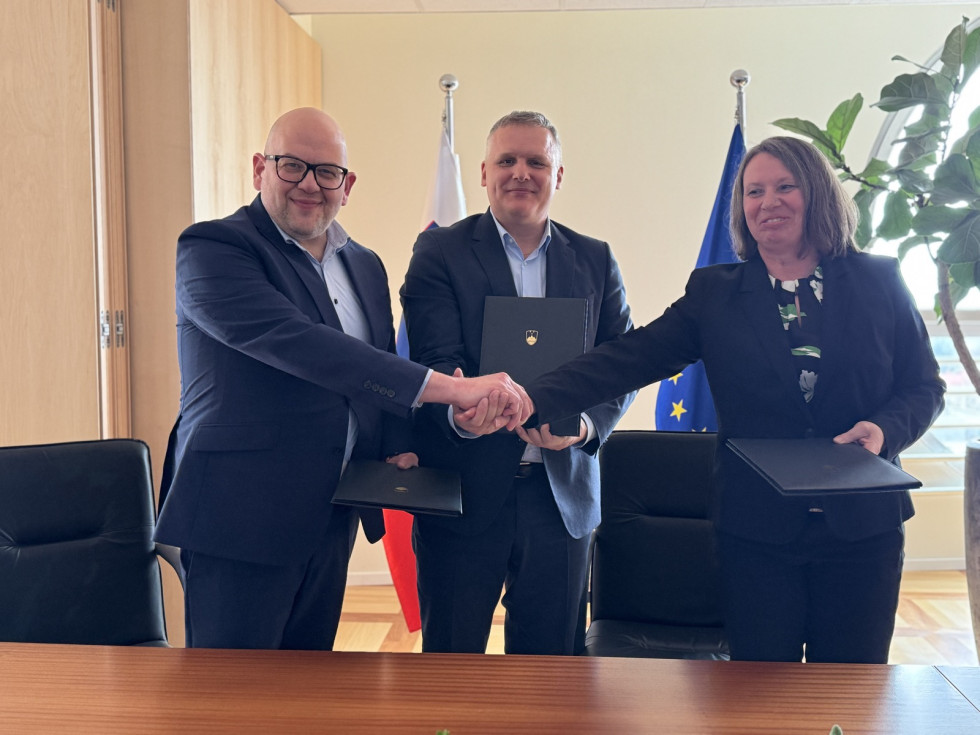 podpisniki s sklenjenimi rokami in podpisnimi mapami