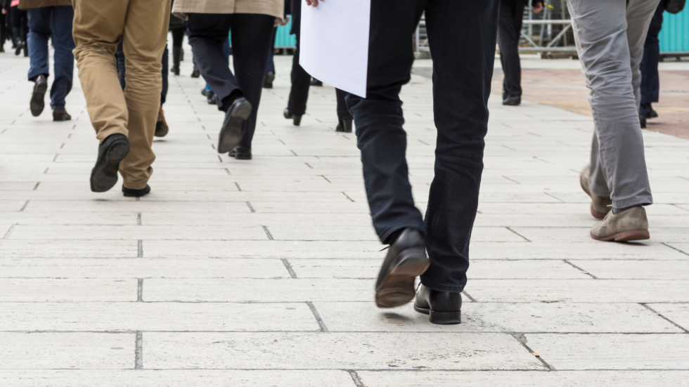 noge ljudi, ki pešačijo po beli tlakovani poti