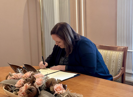 Dr. Vesna Mesec-Baligač, okrajna državna tožilka na Okrožnem državnem tožilstvu v Ljubljani, sede podpisuje potrdilo o prisegi v sejni sobi Ministrstva za pravosodje.