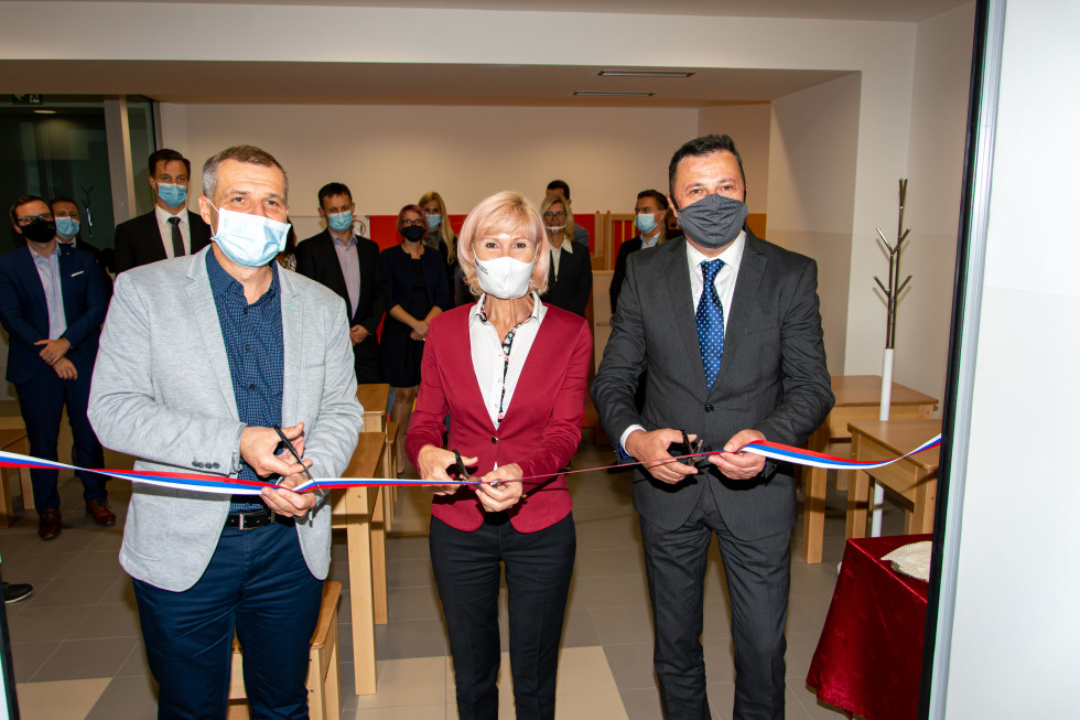 z leve proti desni direktor Zavoda za prestajanje kazni zapora Maribor Robert Šilc, ministrica za pravosodje mag. Lilijana Kozlovič in generalni direktor Uprave za izvrševanje kazenskih sankcij režejo trak ob odprtju novih prostorov za obiske zaprtih oseb