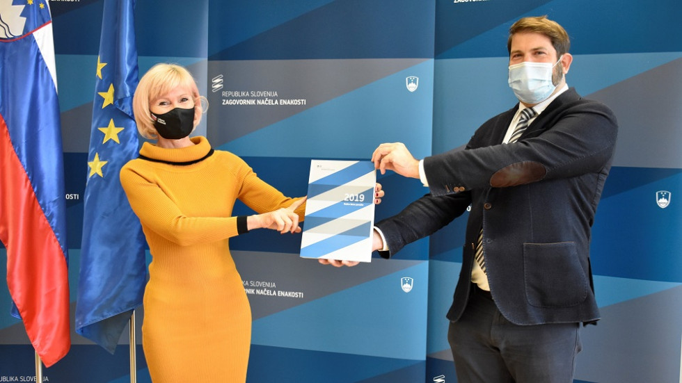 Ministrica za pravosodje Lilijana Kozlovič in zagovornik načela enakosti stojita in v roki držita letno poročilo zagovornika v letu 2019
