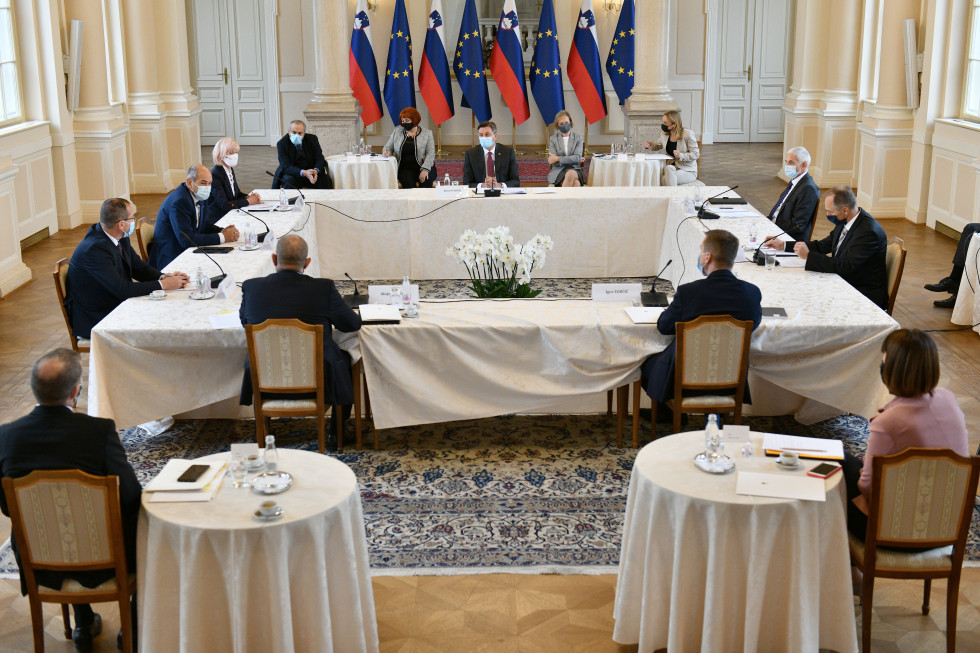 Udeleženci srečanja sedijo za mizo
