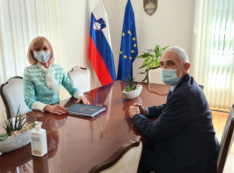 Ministrica (na desni strani slike) in predsednik VSRS (na levi strani slike) na pogovoru za mizo v pisarni ministrice
