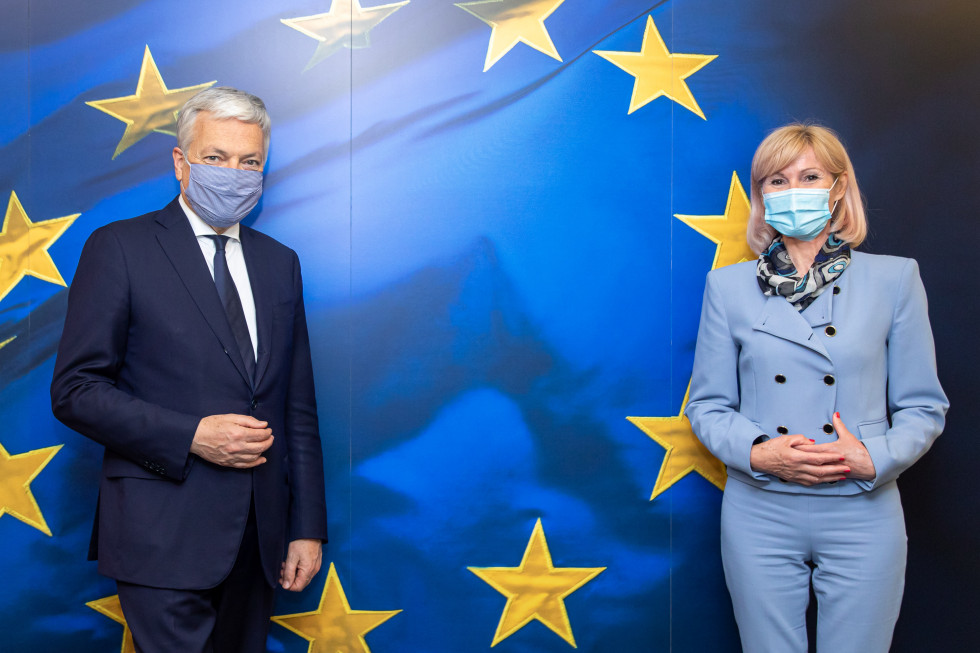 Ministrica Kozlovič na sliki desno, ter komisar Reynders, na sliki levo, slikana pred evropsko zastavo