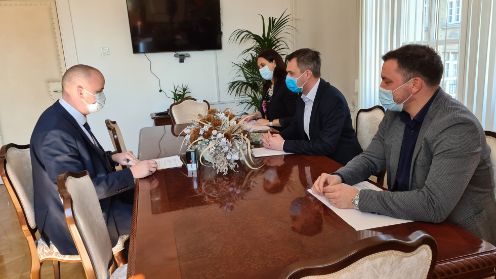 Predstavniki ministrstva za pravosodje in direktor SCNR  v pogovoru sedijo za mizo v pisarni ministra