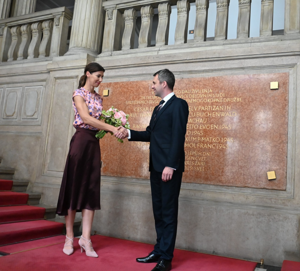 ministrica in minister slikana na stopnicah, minister predaja šopek rož