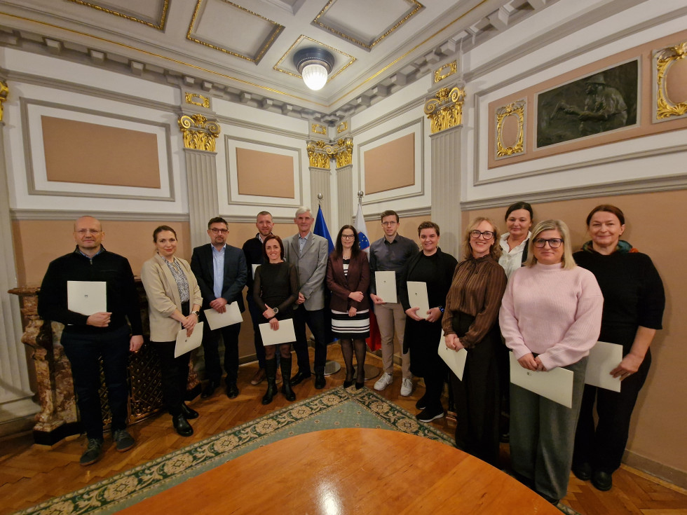 Skupinska slika sodnih cenilcev in tolmača skupaj z državno sekretarko