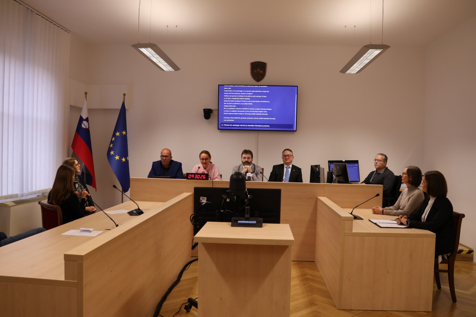 sodelujoči na novinarski konferenci sedijo za dvignjenim omizjem