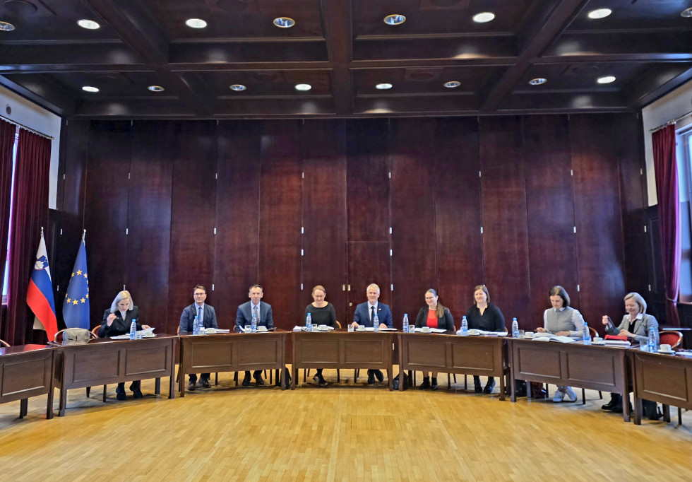 člani implementacijske skupine sedijo za mizami, razporejenimi v velikem krogu, v veliki sodni dvorani