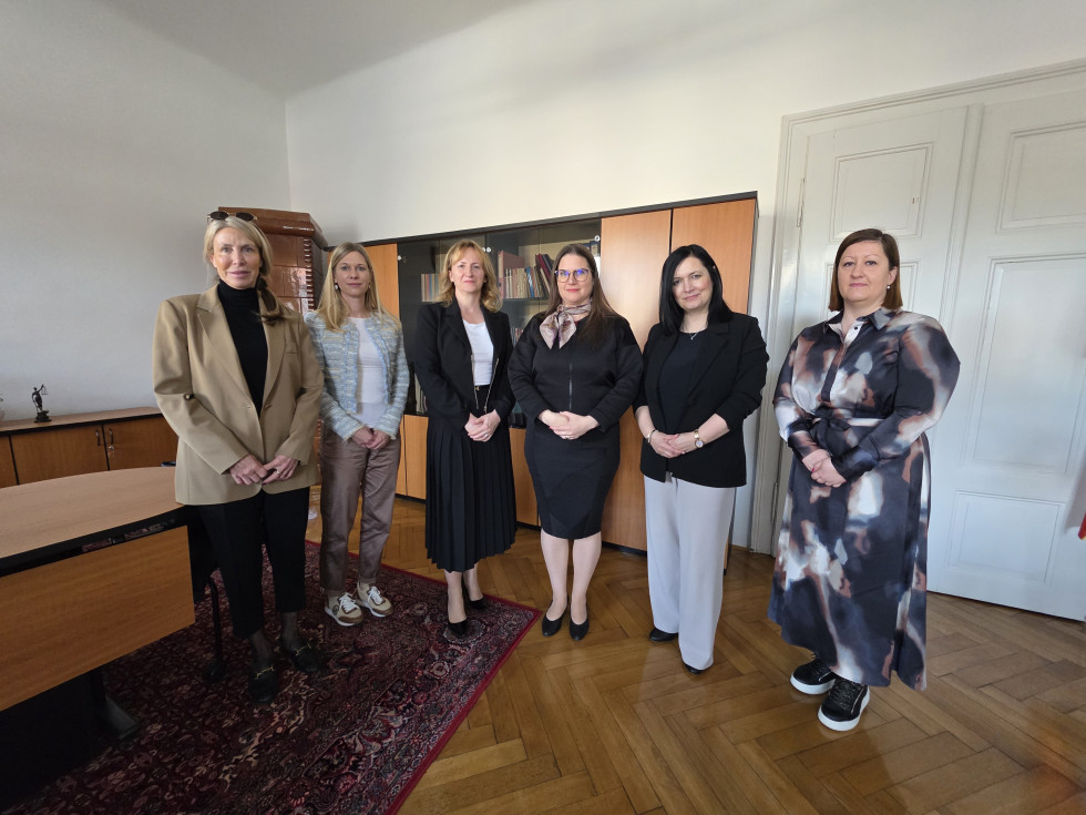 Ženske stojijo v pisarni ena zraven druge.