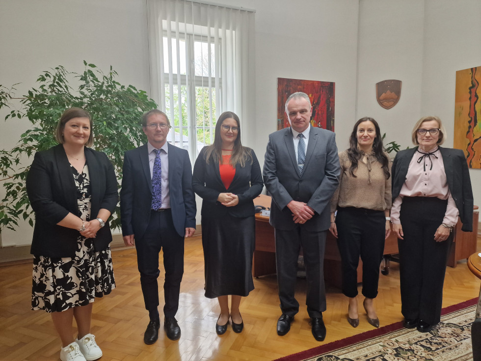 Ministrica za pravosodje mag. Andreja Kokalj z zaposlenimi na sodišču med obiskom, vsi stojijo v pisarniškem prostoru.