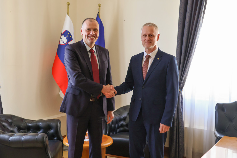 Minister in predsednik VSRS se rokujeta pred slovensko in evropsko zastavo