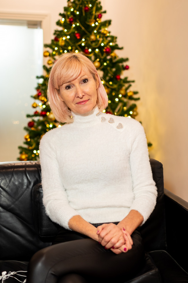 Ministrica pravosodja mag. Lilijana Kozlovič sedi pred božičnim drevescem.