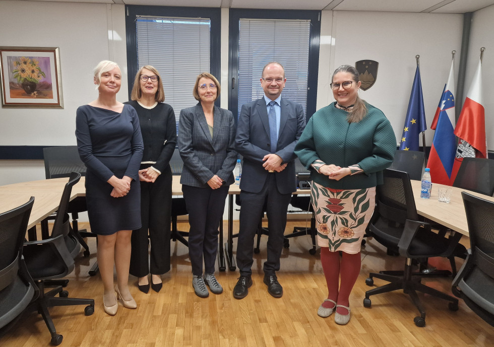 Ministrica mag. Andreja Kokalj na skupinski sliki z vodstvom Okrožnega državnega tožilstva v Mariboru. V ozadju zastave.