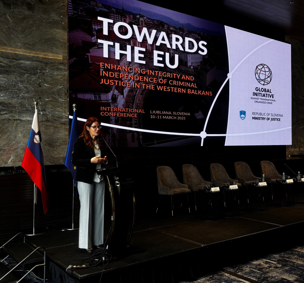 Ministrica stoji na odru in zaključuje konferenco