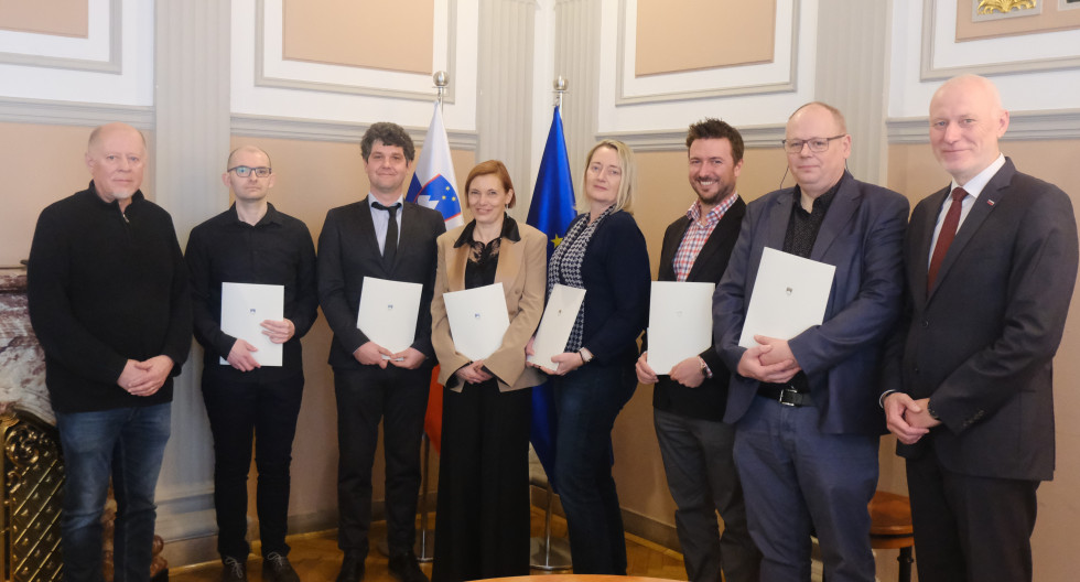 Skupinska fotografija novih sodnih izvedencev, sodne cenilke in sodnega tolmača z državnim sekretarjem dr. Milanom Brglezom in namestnikom predsednika Strokovnega sveta za sodno izvedenstvo, cenilstvo in tolmačenje mag. Brankom Kovačem. 