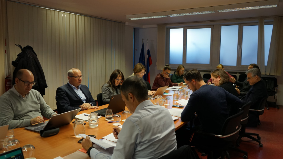 Člani stanovanjskega sveta sedijo za mizo in razpravljajo