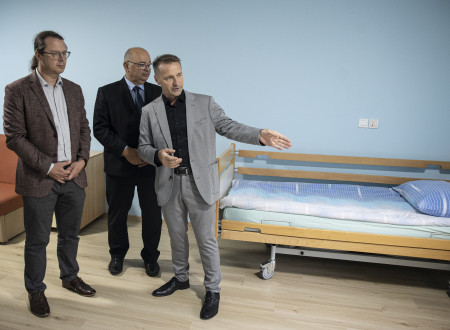 Državni sekretar si ogleduje prostore, zadaj postelja