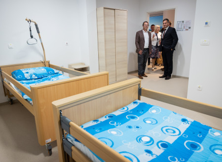 Omladič si ogleduje sobo v domu za starejše, v ospredju dve postelji