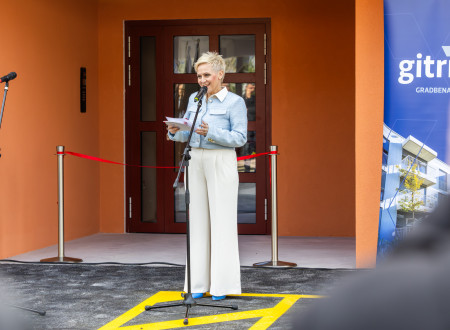 Povezovalka programa stoji pred mikrofonom