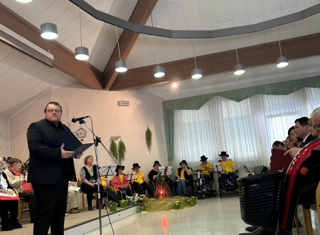 Minister ima nagovor, pred njim mikrofon, v ozadju stanovalke in stanovalci doma starejših