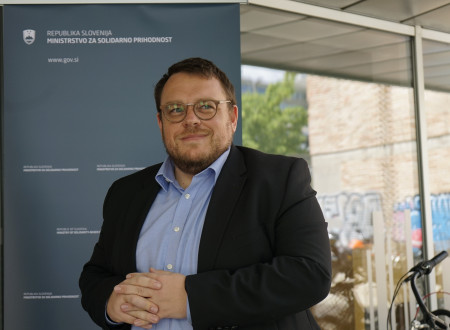 Minister stoji pred reklamnim panojem ministrstva