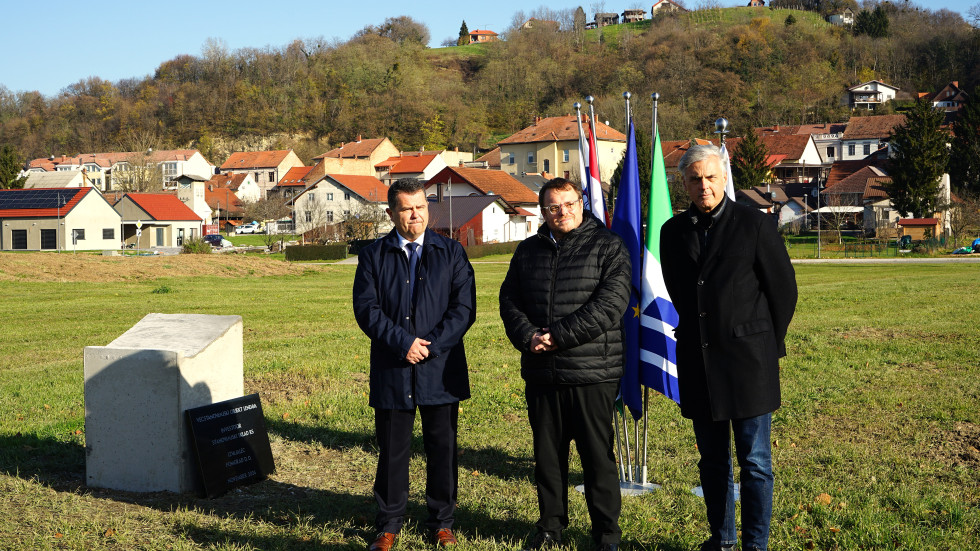 Zbrani ob temeljnem kamnu v ozadju zastave