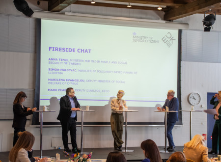 Udeleženci pogovora stojijo pred panojem