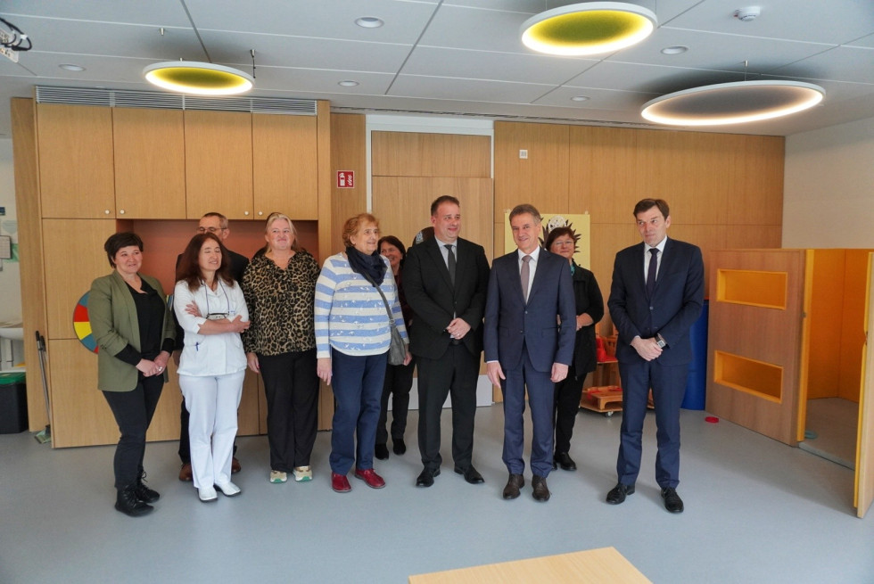 Predsednik vlade in minister za vzgojo in izobraževanje v prostorih centra skupaj z zaposlenimi stojijo v vrsti