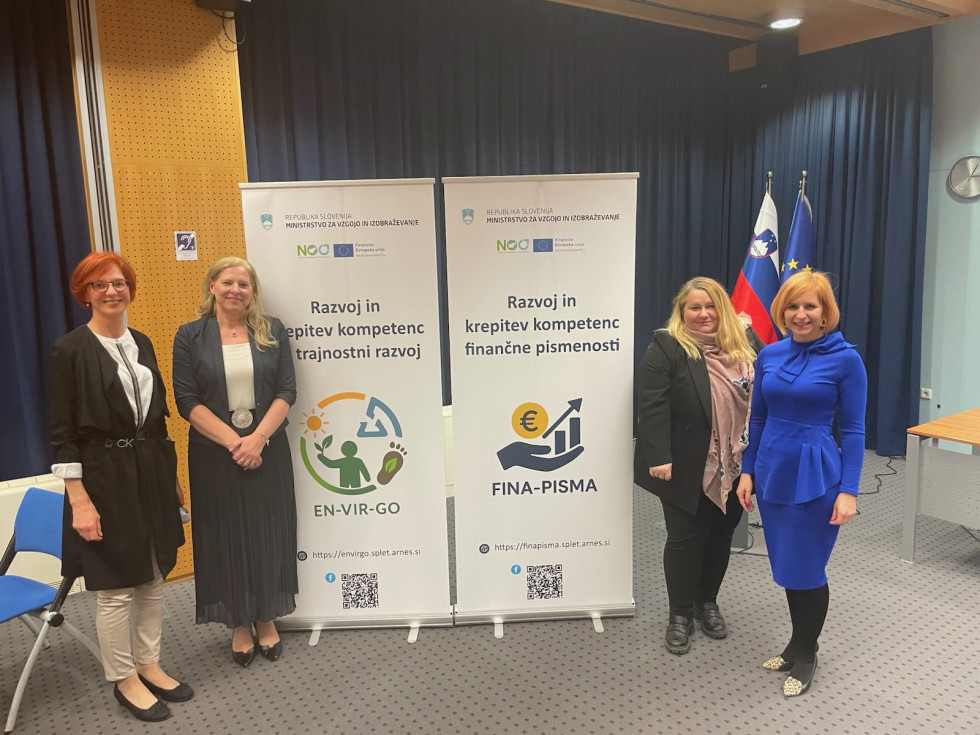 Državna sekretarka pred panojem, ki predstavlja vsebino srečanja.