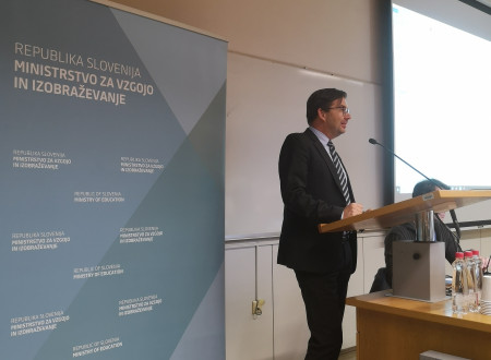 Vodja delovne skupine dr. Janez Vogrinc za pultom nagovarja udeležence javne predstavitve mnenj o predšolski vzgoji
