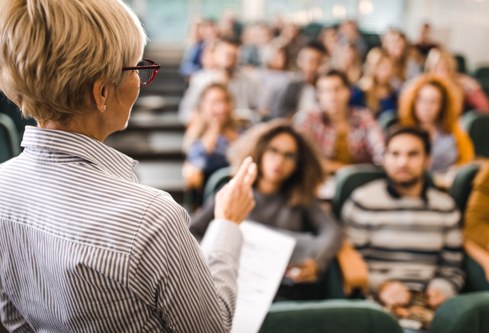 Profesorica med predavanjem študentom v predavalnici