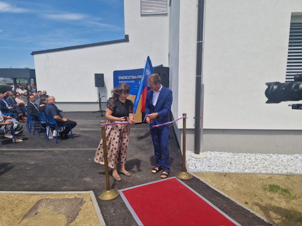 Državna sekretarka med rezanjem otvoritvenega traku pred šolo v Mariboru
