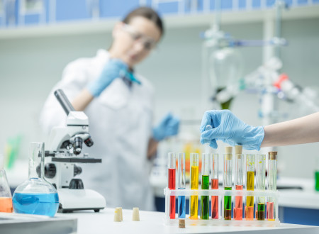 Raziskovalka v laboratoriju, v ospredju epruvete.