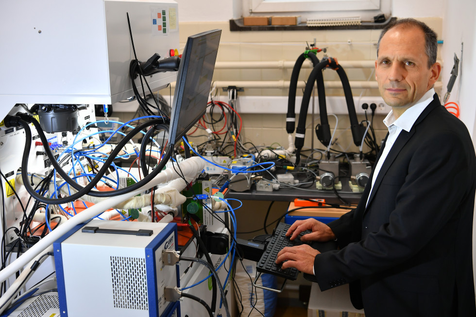 Portretna fotografija dr. Tomaža Katrašnika ob električni polnilnici pri polnjenju električnega avtomobila.