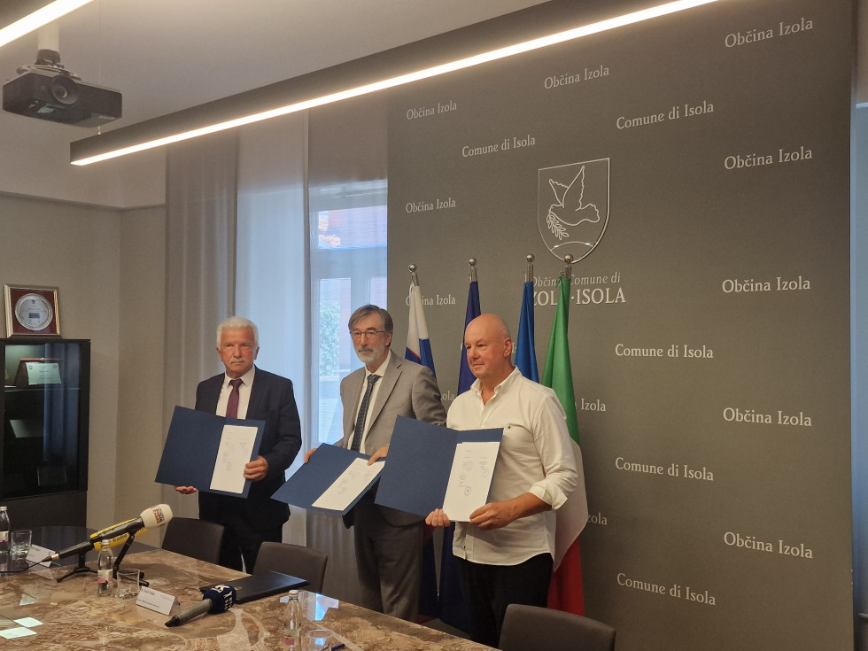 Minister dr. Darjo Felda, župan Občine Izola Milan Bogatič in ravnatelj Srednje šole Pietro Coppo Izola v rokah držijo podpisano pismo.