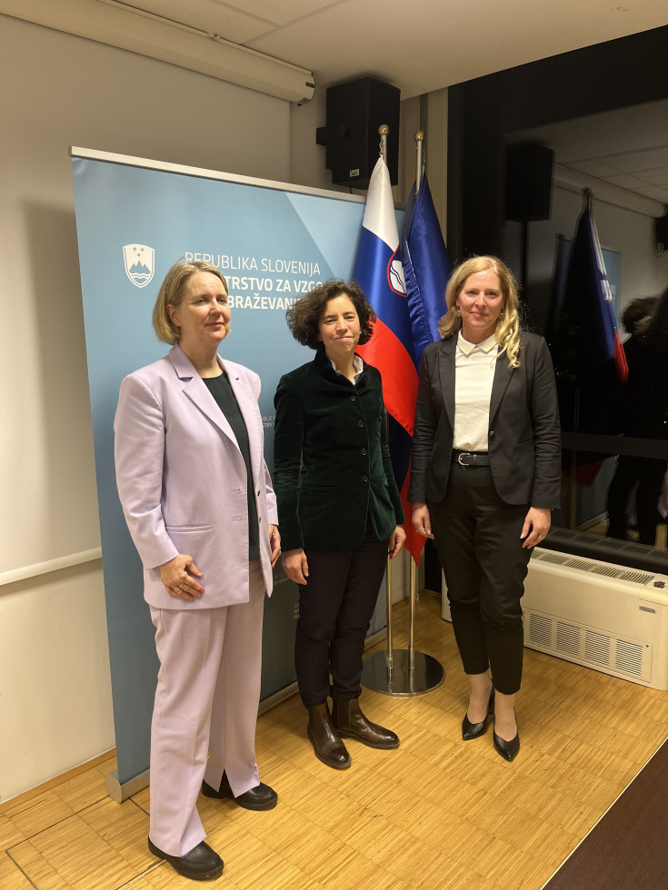 Državna sekretarka Janja Zupančič, veleposlanica Zvezne republike Nemčije v Sloveniji Sylvia Groneick in pooblaščenka za kulturo na nemškem zunanjem ministrstvu Anne Bartels stojijo pred panojem ministrstva.