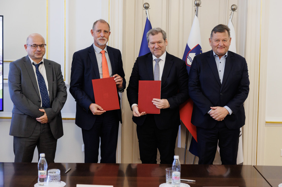 Od leve proti desni: dekan Fakultete za strojništvo prof. dr. Jernej Klemenc, rektor prof. dr. Gregor Majdič, minister dr. Igor Papič in minister dr. Jevšek pred zastavami Slovenije, Evropske unije in Univerze v Ljubljani.